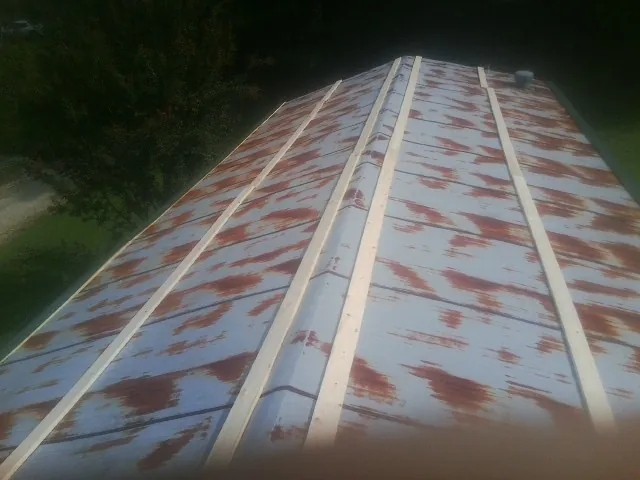 Rusted metal roof panels with new wood purlins before replacement — Storm Damage Roof Repair in Cuttyhunk by Roofing Brothers