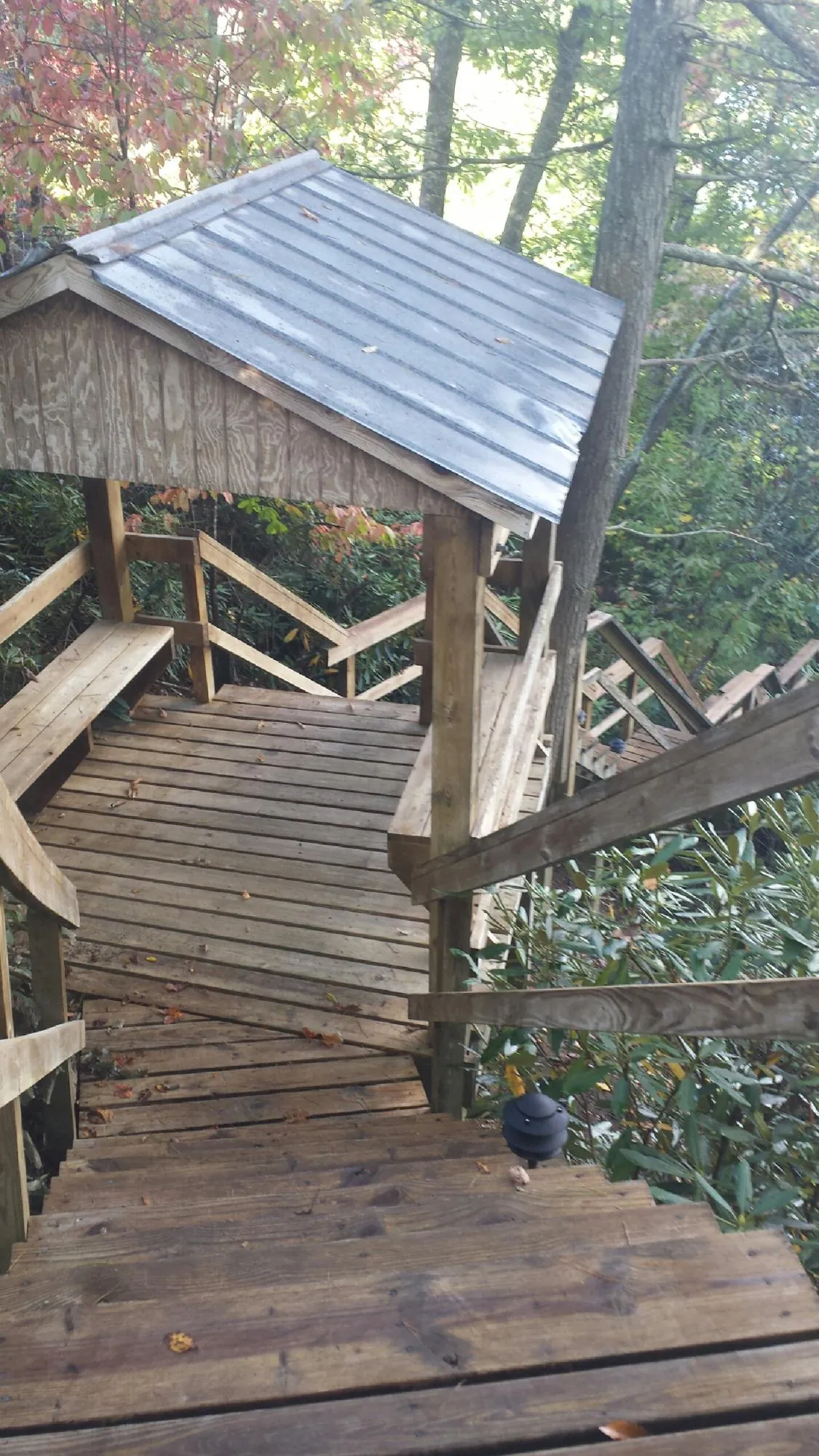 Metal roofed shelter over wooden steps on a wooded walkway — Skylight Repair & Installation work by our crew in Cuttyhunk
