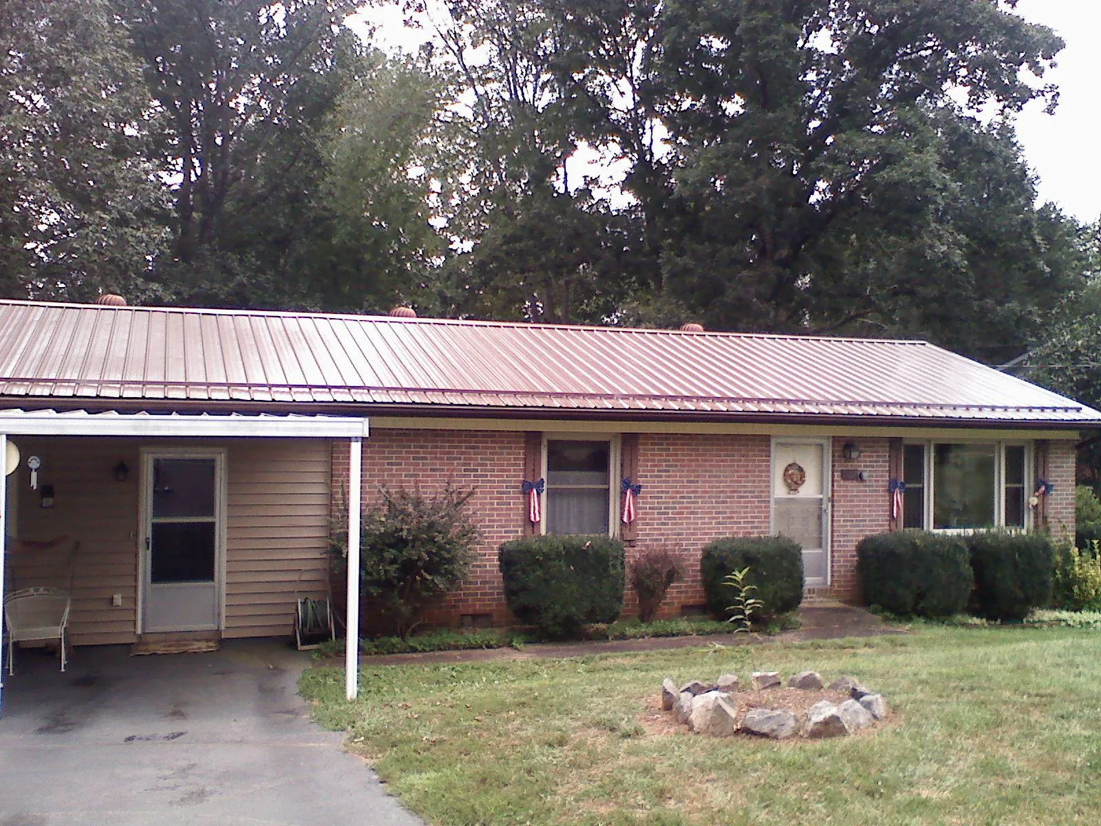 Bronze metal roof and carport on a brick ranch home — Roof Repair work by our crew in Cuttyhunk